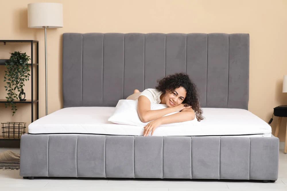 Woman lying on her bed smiling