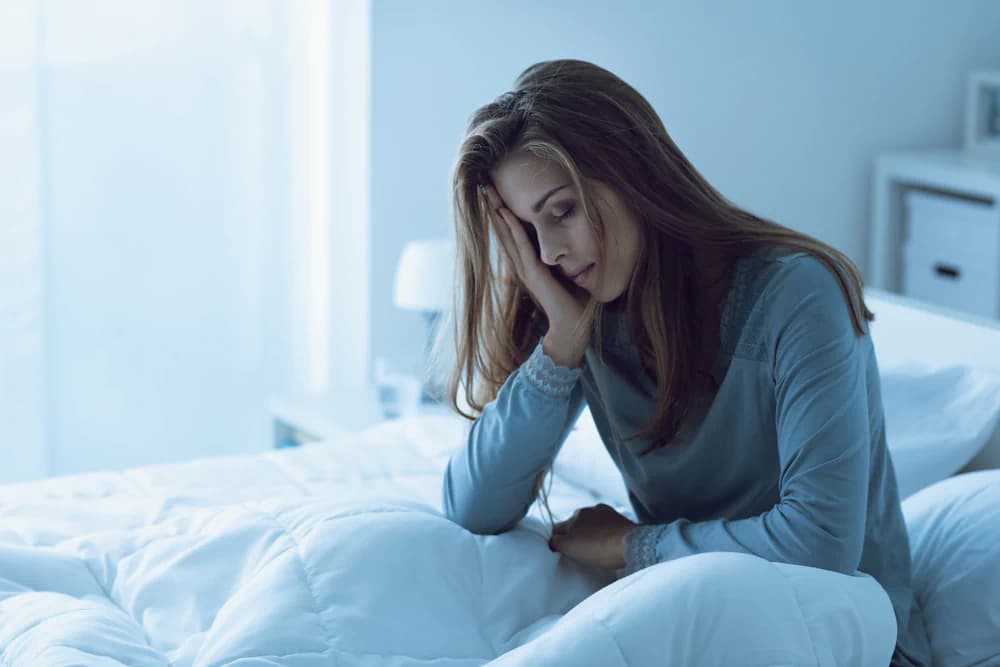 Depressed woman in bed struggling with sleep deprivation