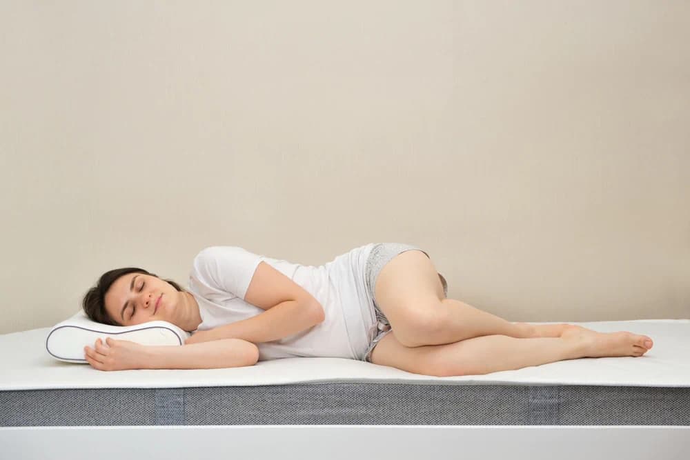 Woman sleeping on bed with mattress body impressions