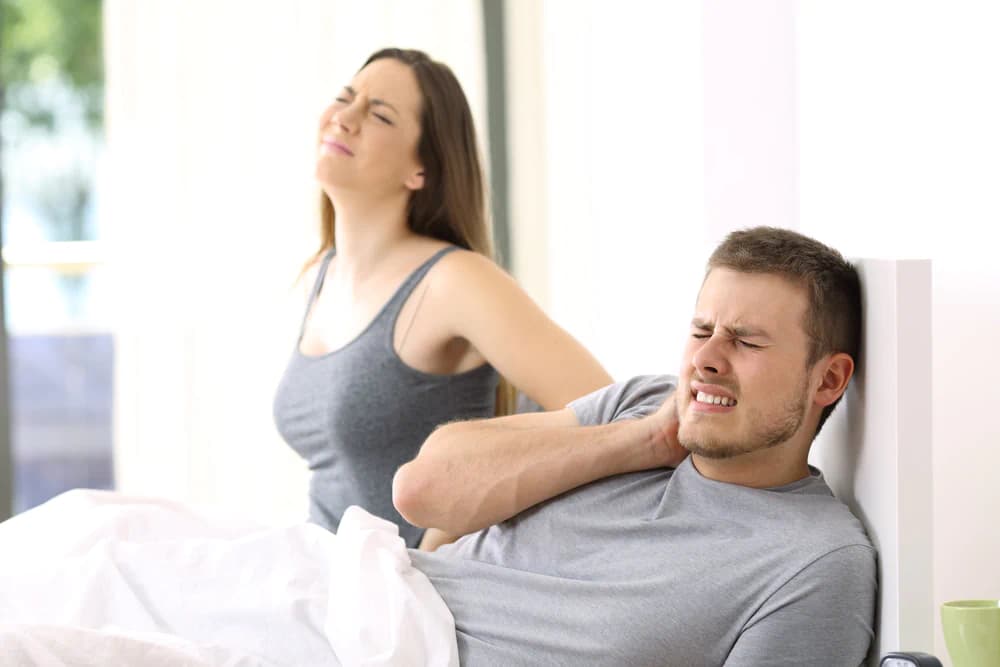 Couple waking up with back, shoulder, and neck pain