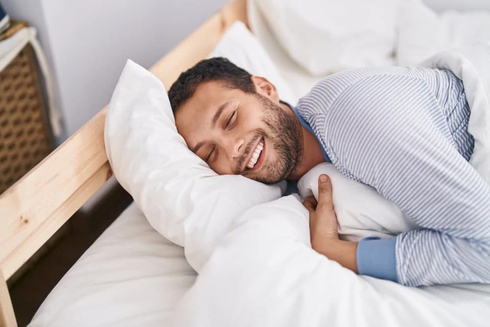 Happy man smiling on his mattress