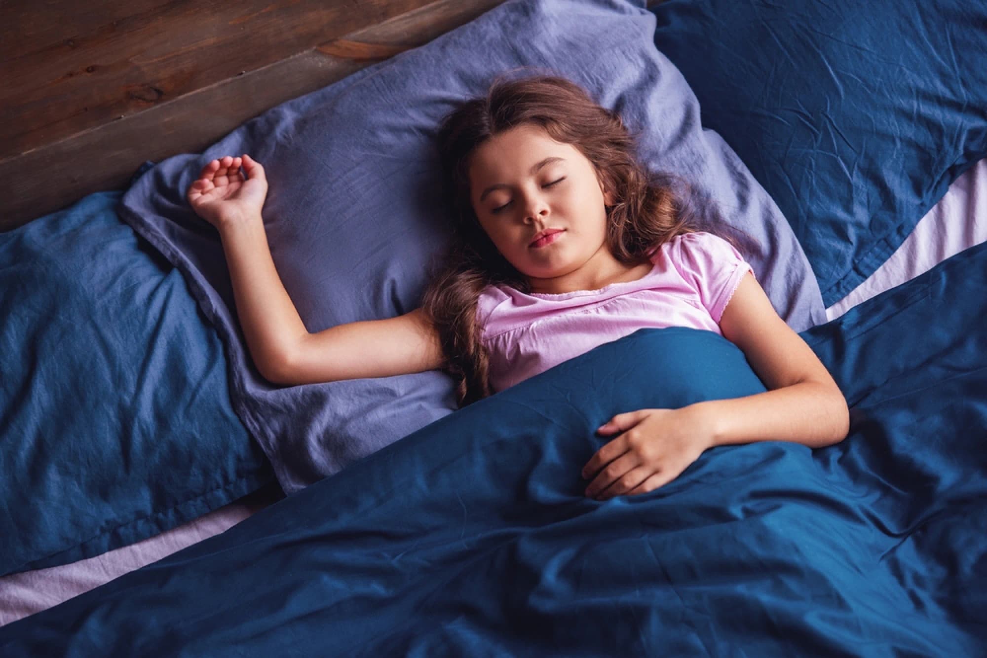 Young girl asleep in a kids queen bed
