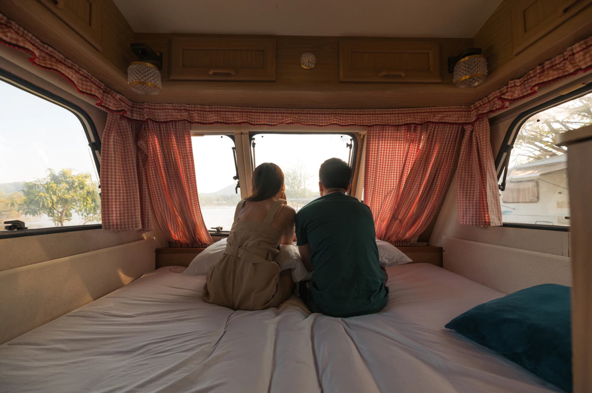 Couple sitting on mattress in camper RV