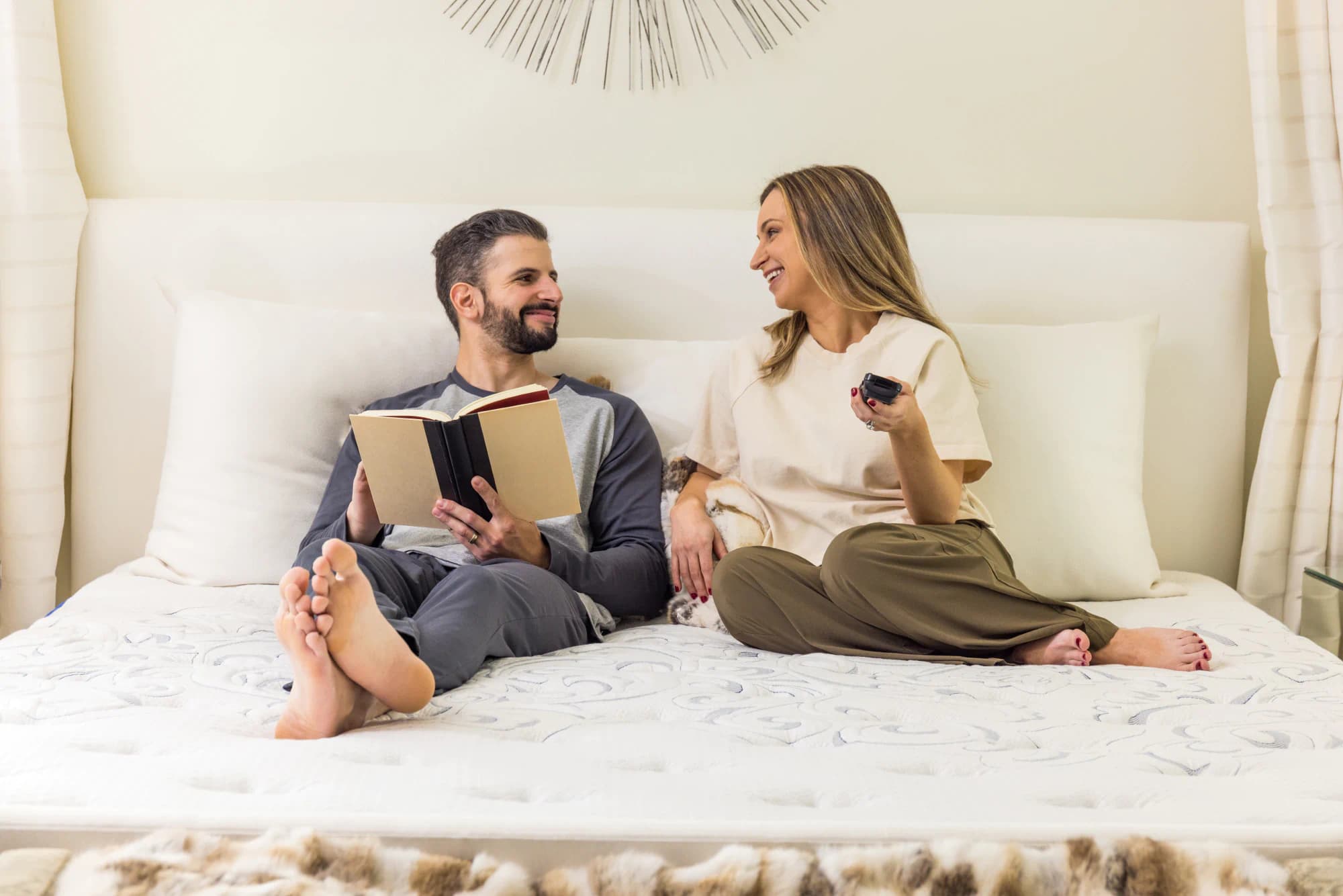 Couple watching TV and reading on a mattress with an adjustable base