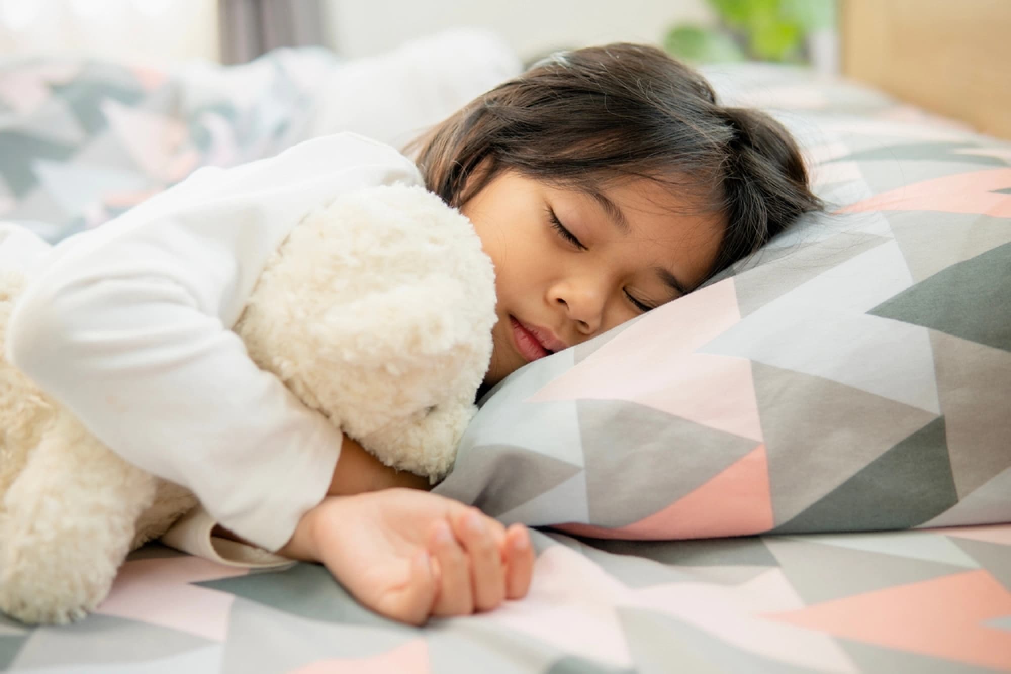Young girl asleep in her bed
