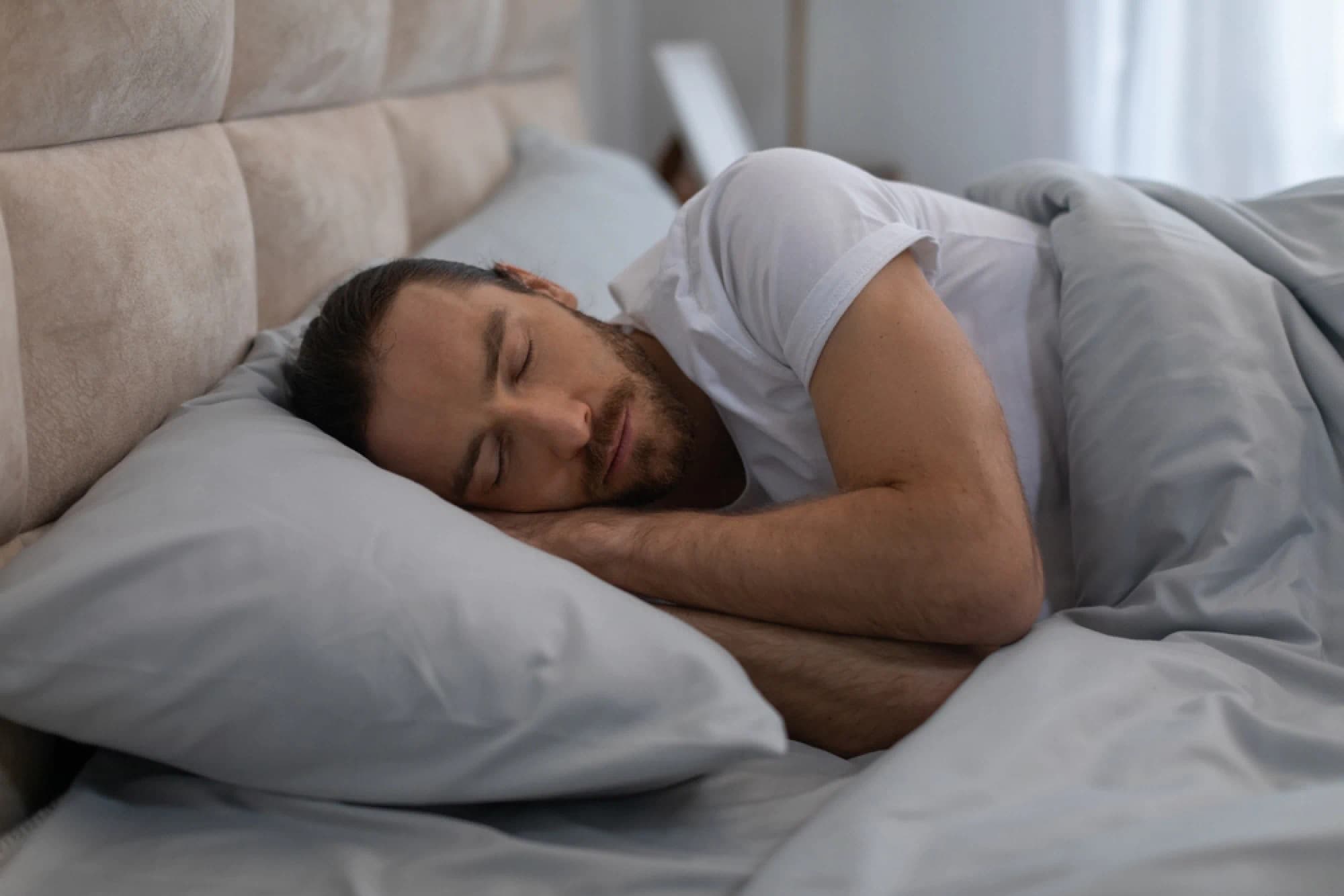 Man side sleeping wearing a white t-shirt