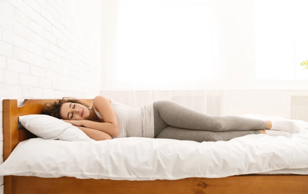 Woman lying on her side in bed.