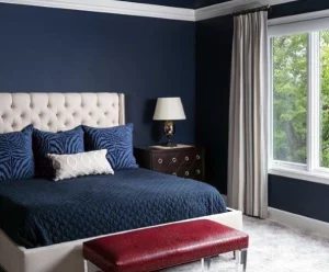 Bed with white headboard, a navy quilt and navy pillows