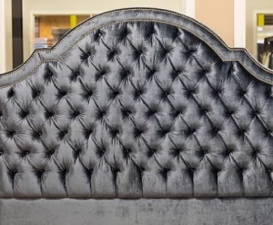 Dark gray bed headboard with a tufting design