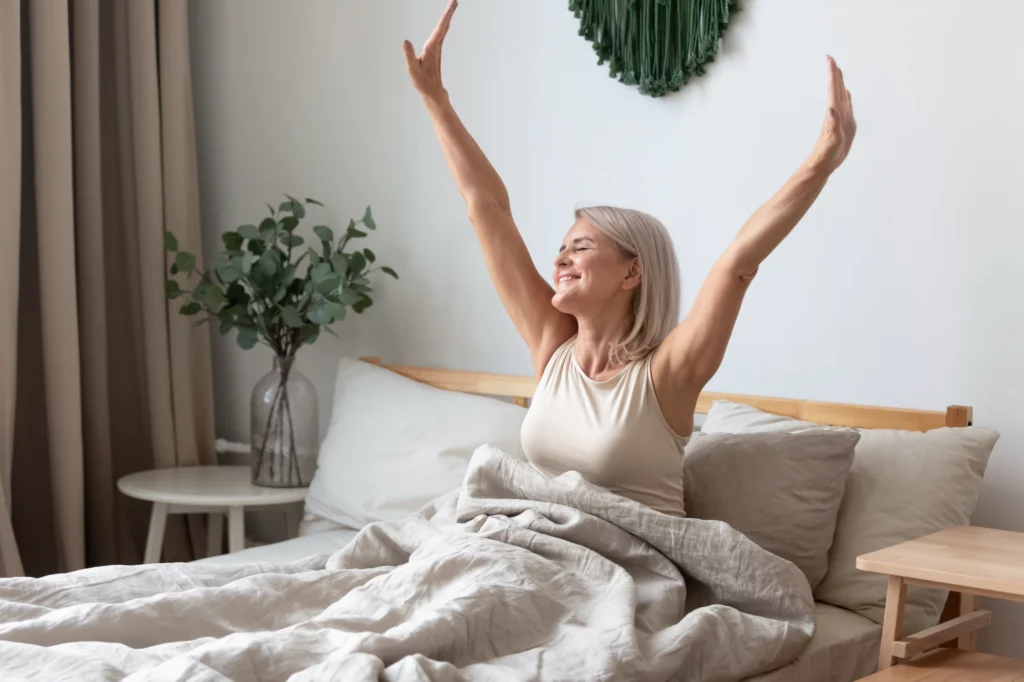 Older woman stretching in bed