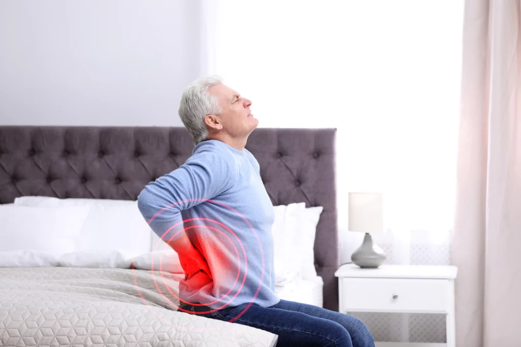 Elderly man on the bed suffering from back pain.